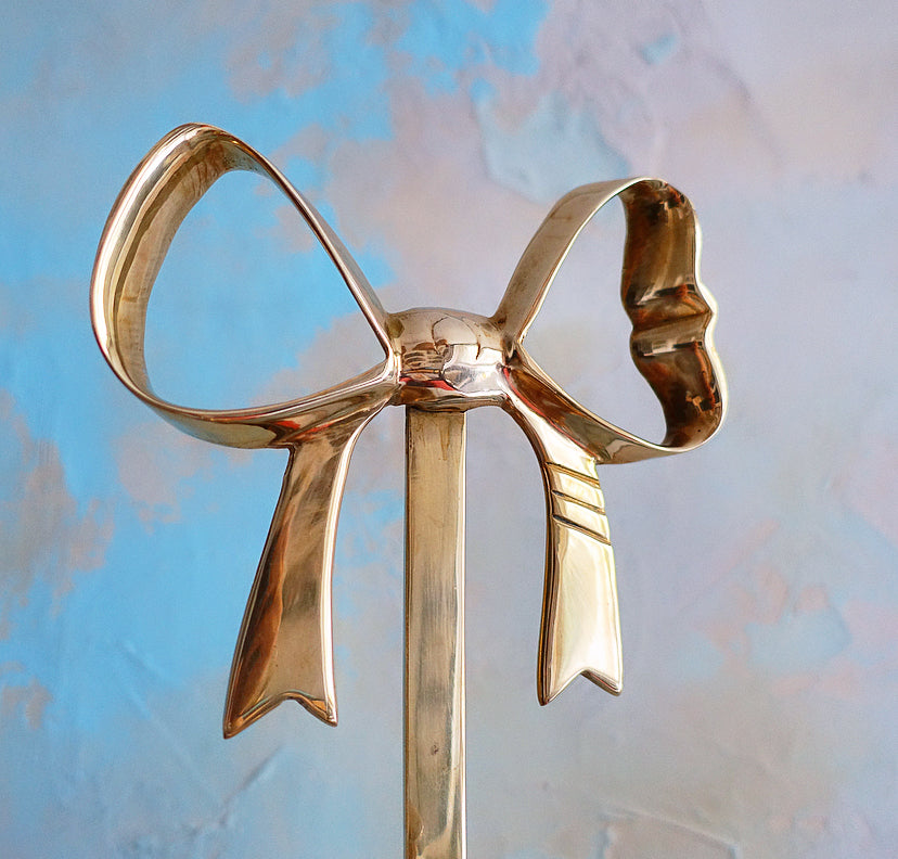 Pair of Hollywood Regency brass bow candle sconces