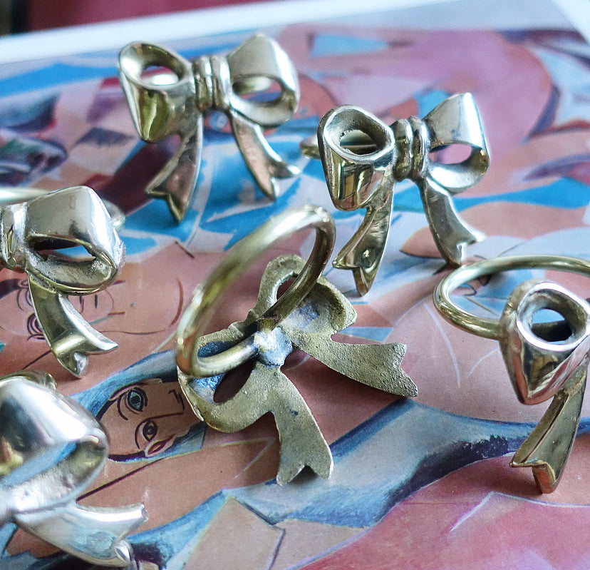 Set of six Hollywood regency brass bow napkin rings