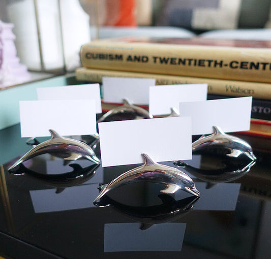 Set of six metal dolphin place card holders