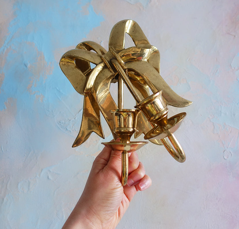 Pair of Hollywood Regency brass bow candle sconces