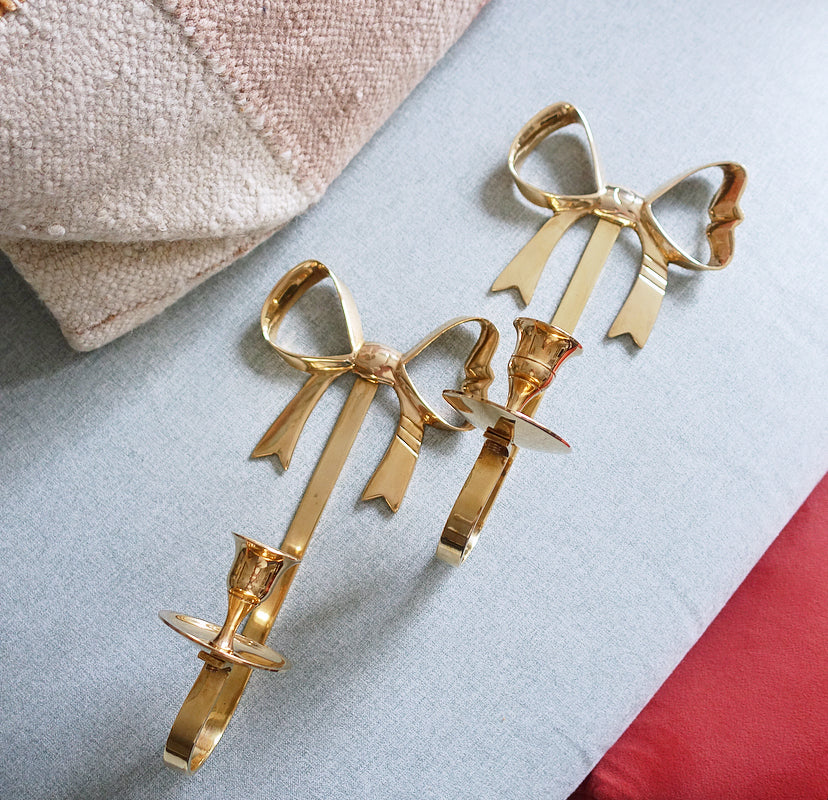 Pair of Hollywood Regency brass bow candle sconces