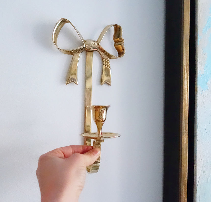 Pair of Hollywood Regency brass bow candle sconces