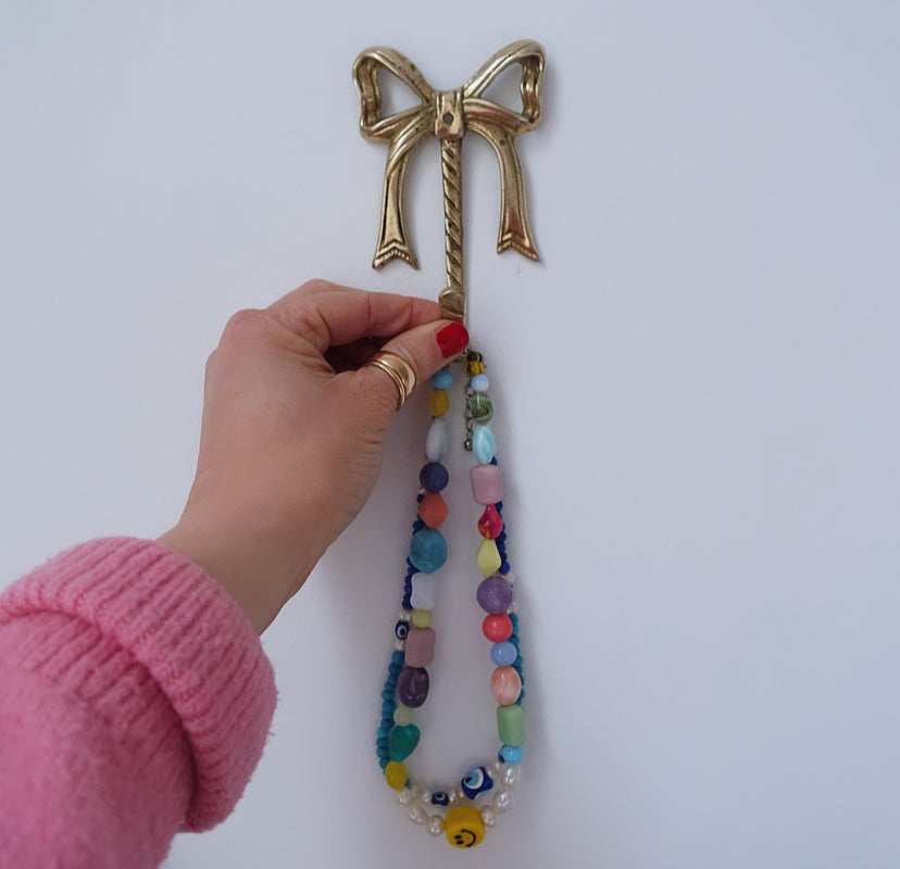 Pair of brass Hollywood Regency bow hooks