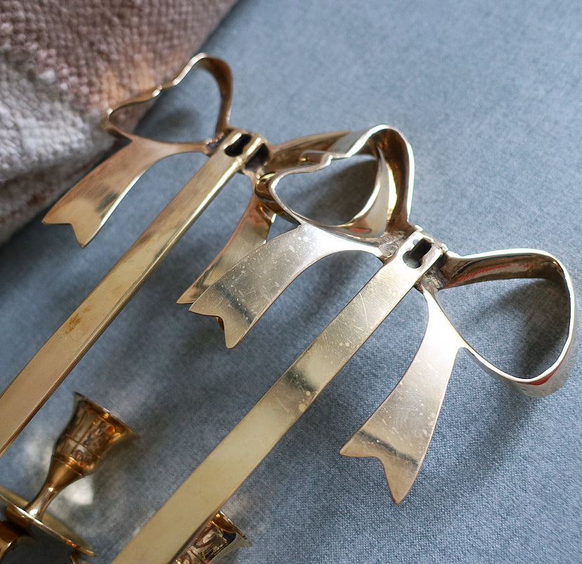 Pair of Hollywood Regency brass bow candle sconces