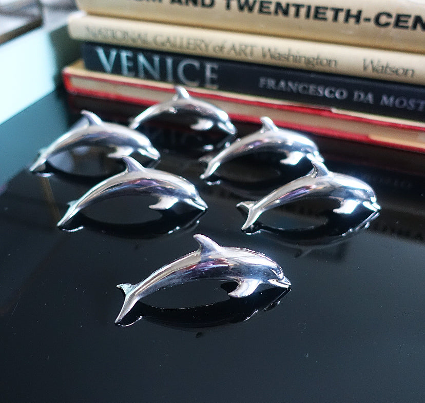 Set of six metal dolphin place card holders